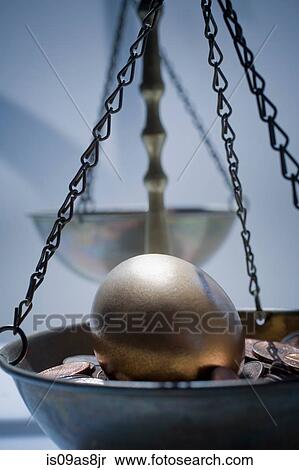 Golden egg on bed of coins in weighing scales View Large Photo Image Stock Photography - Golden egg on bed of coins in weighing scales. Fotosearch