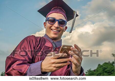 Picture - Graduate taking selfie with smartphone. Fotosearch