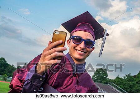 Graduate taking selfie with smartphone View Large Photo Image Picture - Graduate taking selfie with smartphone. Fotosearch
