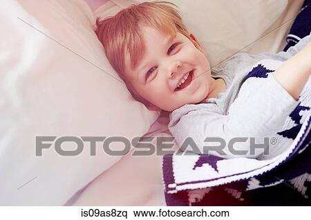 Stock Photography - High angle view of boys head and shoulders, looking at camera smiling. Fotosearch