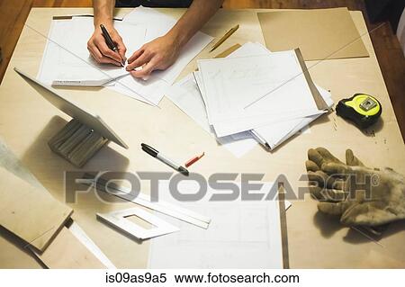 Stock Photography - High angle view of desk and young mands hands writing. Fotosearch