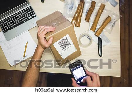 High angle view of young mans hands using smartphone to scan delivery label on package View Large Photo Image Stock Image - High angle view of young mans hands using smartphone to scan delivery label on package. Fotosearch