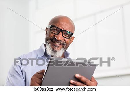 Mature man using digital tablet in office View Large Photo Image Stock Photo - Mature man using digital tablet in office. Fotosearch