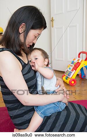 Mature mother sitting on floor with baby son on lap View Large Photo Image Stock Image - Mature mother sitting on floor with baby son on lap. Fotosearch