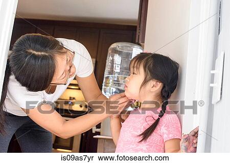 Stock Photography - Mother wiping daughter's face. Fotosearch