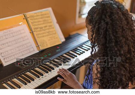 Over shoulder view of girl playing keyboard View Large Photo Image Stock Image - Over shoulder view of girl playing keyboard. Fotosearch
