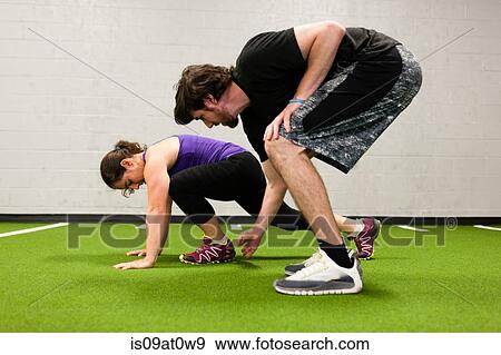 Personal trainer working with mid adult woman in gym View Large Photo Image Stock Photo - Personal trainer working with mid adult woman in gym. Fotosearch
