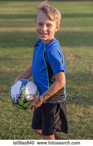 Portrait of boy football player holding football on practice pitch View Large Photo Image Stock Image - Portrait of boy football player holding football on practice pitch. Fotosearch