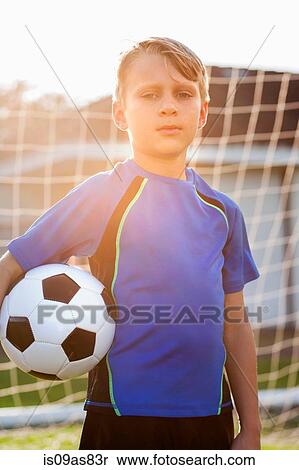 Stock Photography - Portrait of boy football player holding football in front of goal. Fotosearch