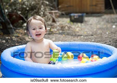 Portrait of cute baby boy playing in garden paddling pool View Large Photo Image Stock Photo - Portrait of cute baby boy playing in garden paddling pool. Fotosearch