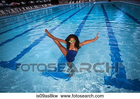 Portrait of girl standing on one leg in swimming pool wearing goggles, leg raised, looking at camera, smiling View Large Photo Image Stock Photo - Portrait of girl standing on one leg in swimming pool wearing goggles, leg raised, looking at camera, smiling. Fotosearch