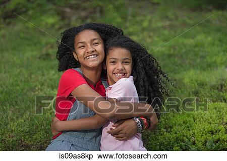 Portrait of girls hugging looking at camera smiling View Large Photo Image Stock Photography - Portrait of girls hugging looking at camera smiling. Fotosearch