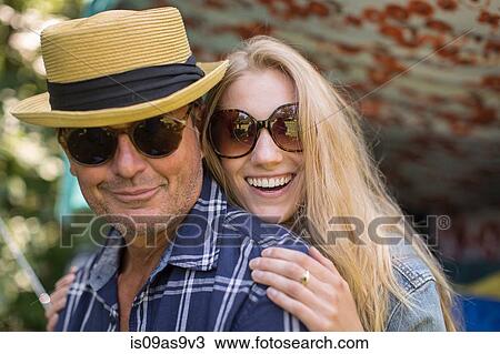 Stock Image - Portrait of mature man and girlfriend wearing sunglasses. Fotosearch