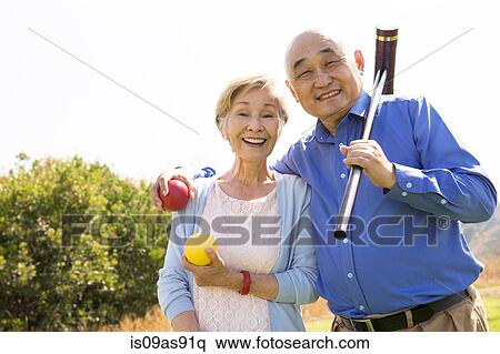 Portrait of senior couple in park, holding croquet mallet and balls View Large Photo Image Stock Photography - Portrait of senior couple in park, holding croquet mallet and balls. Fotosearch