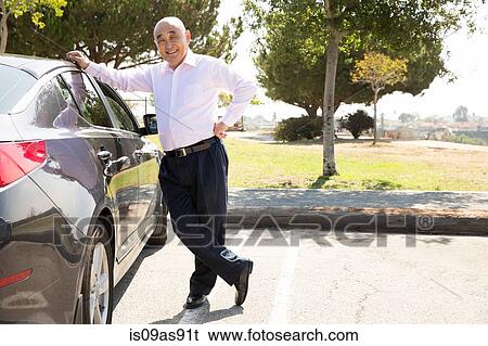 Stock Photograph - Portrait of senior man, standing beside car. Fotosearch