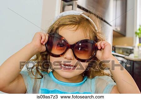 Stock Image - Portrait of young girl, wearing sunglasses. Fotosearch