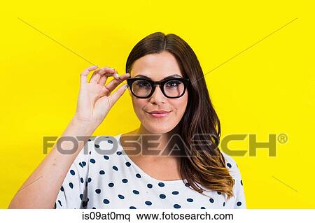 Stock Photography - Portrait of young woman holding eyeglasses. Fotosearch
