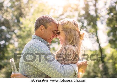 Romantic mature man hugging girlfriend in garden View Large Photo Image Picture - Romantic mature man hugging girlfriend in garden. Fotosearch