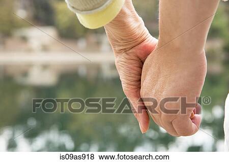 Senior couple holding hands, focus on hands, close-up View Large Photo Image Stock Photo - Senior couple holding hands, focus on hands, close-up. Fotosearch