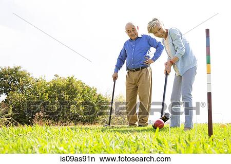Senior couple playing croquet in park View Large Photo Image Picture - Senior couple playing croquet in park. Fotosearch