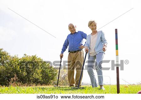 Picture - Senior couple playing croquet in park. Fotosearch