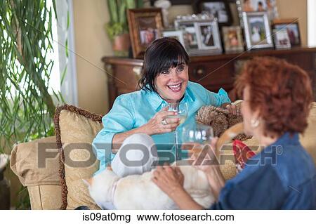 Senior woman at home, sitting on sofa, talking to friend View Large Photo Image Stock Image - Senior woman at home, sitting on sofa, talking to friend. Fotosearch