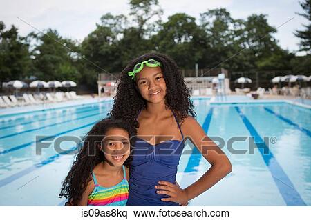 sisters wearing swimsuits standing in front of swimming pool, looking at camera smiling View Large Photo Image Stock Photography - sisters wearing swimsuits standing in front of swimming pool, looking at camera smiling. Fotosearch