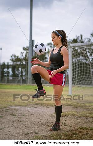 Soccer player bouncing ball on knee in field View Large Photo Image Stock Photo - Soccer player bouncing ball on knee in field. Fotosearch