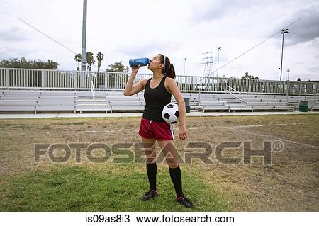 Stock Image - Soccer player drinking in field. Fotosearch
