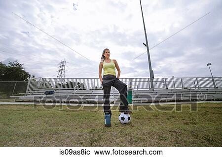 Stock Image - Soccer player stepping on ball in field. Fotosearch