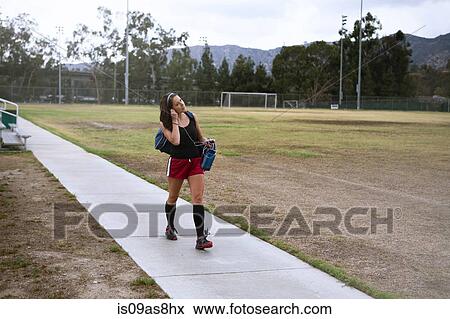 Stock Photo - Soccer player using smartphone in field. Fotosearch