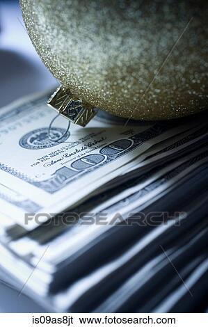 Sparkly christmas bauble on top of pile of 100 dollar bills View Large Photo Image Stock Photograph - Sparkly christmas bauble on top of pile of 100 dollar bills. Fotosearch