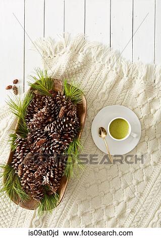 Stock Image - Still life with pine cones and needles and cup of matcha tea. Fotosearch