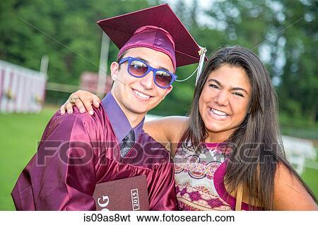 Stock Photograph - Student celebrates graduation with friend. Fotosearch