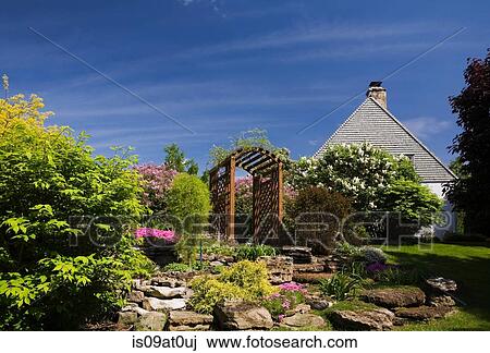 Wooden arbour in garden with flowers growing around View Large Photo Image Stock Image - Wooden arbour in garden with flowers growing around. Fotosearch
