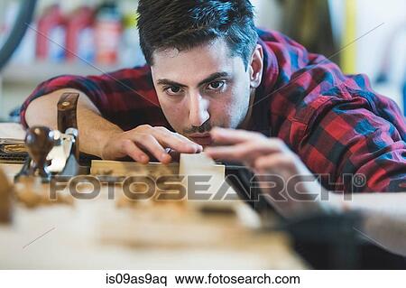 Young man using wood plane to smooth wood object View Large Photo Image Stock Photography - Young man using wood plane to smooth wood object. Fotosearch