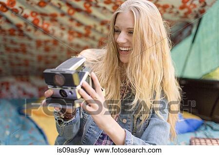 Young woman photographing with instant camera whilst camping View Large Photo Image Stock Photo - Young woman photographing with instant camera whilst camping. Fotosearch