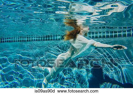 Young woman swimming underwater, wearing thin white shirt View Large Photo Image Stock Image - Young woman swimming underwater, wearing thin white shirt. Fotosearch