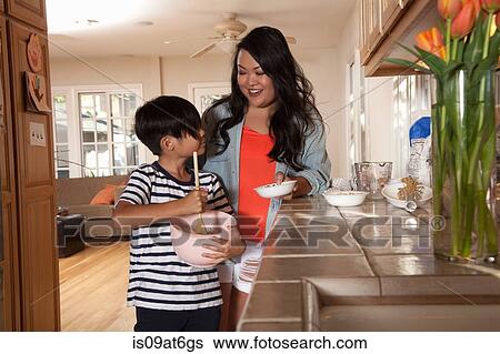 Stock Photograph - Boy helping mother with mixing in kitchen. Fotosearch