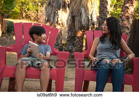Boy showing mother digital tablet in garden View Large Photo Image Stock Photo - Boy showing mother digital tablet in garden. Fotosearch