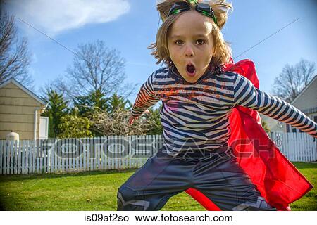 Picture - Boy with red cape pretending to fly. Fotosearch