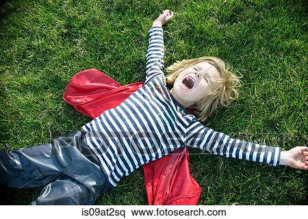 Boy with red cape pretending to fly View Large Photo Image Stock Photography - Boy with red cape pretending to fly. Fotosearch