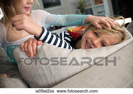 Stock Photo - Children in costumes playing on sofa. Fotosearch