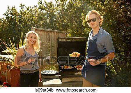 Stock Image - Couple at barbecue party. Fotosearch