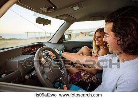 "Couple in car on journey, smiling" View Large Photo Image Picture - "Couple in car on journey, smiling". Fotosearch