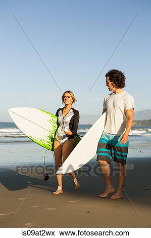 "Couple walking on beach, carrying surfboards" View Large Photo Image Stock Photo - "Couple walking on beach, carrying surfboards". Fotosearch