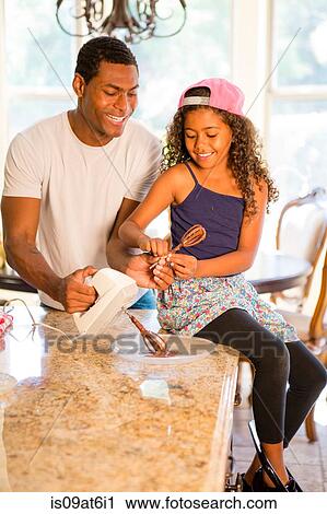 Daughter sitting on kitchen counter helping father with whisk from electric mixer View Large Photo Image Stock Image - Daughter sitting on kitchen counter helping father with whisk from electric mixer. Fotosearch