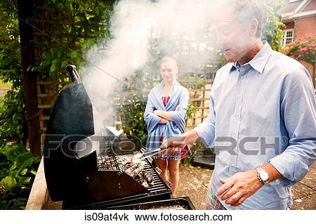 Daughter watching father cook sea food on barbecue View Large Photo Image Stock Image - Daughter watching father cook sea food on barbecue. Fotosearch