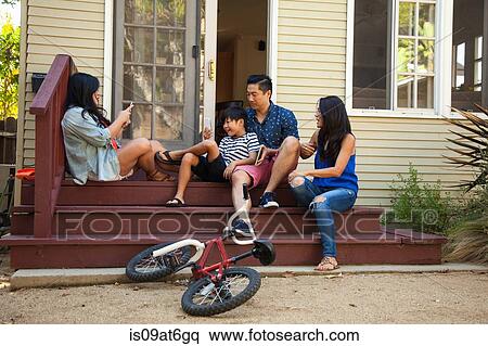 Family posing for smartphone photograph on house steps View Large Photo Image Stock Photography - Family posing for smartphone photograph on house steps. Fotosearch