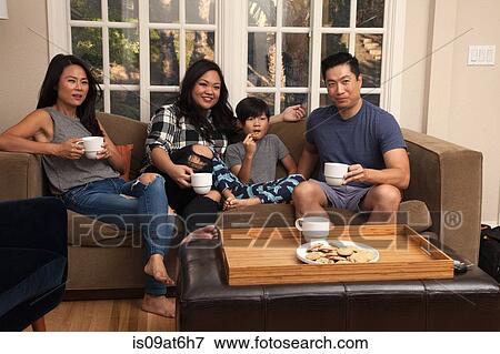 Stock Photo - Family with boy relaxing on sofa and watching TV. Fotosearch